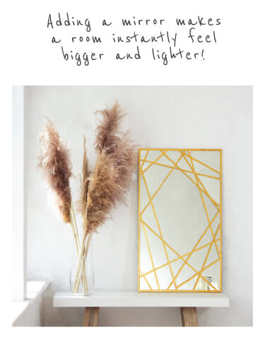 gold framed mirror standing on a console table